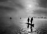 At daybreak, Waurá Indians travel by canoe to collect the “waiting net,” Xingu Indigenous Territory, state of Mato Grosso, Brazil by Sebastião Salgado contemporary artwork photography