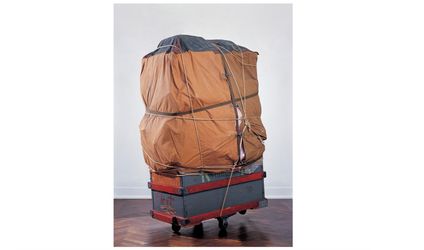 Christo, Dolly (1964). Wood crate on casters, tarpaulin, polyethylene, fabric, ropes, and straps. 183 × 101.5 × 82 cm. © Christo and Jeanne-Claude Foundation. Gagosian.