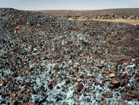 Highly carcinogenic blue asbestos waste on the Owendale Asbestos Mine tailings dump, near Postmasburg, Northern Cape. The prevailing wind was in the direction of the mine officals' houses at right. 21 December 2002 by David Goldblatt contemporary artwork print