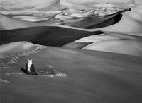 Man praying in the sand dunes in Maor, Tadrart. South of Djanet. Algeria by Sebastião Salgado contemporary artwork photography