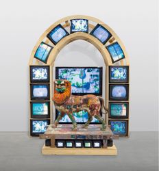 Nam June Paik, Lion (2005). Three-channel video (colour, silent), plasma monitors, CRT monitors, plywood, electrical cables, wood lion sculpture, wood platform, acrylic paint, and permanent oil marker, in 2 parts. Courtesy Gagosian, New York.