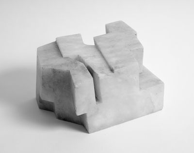 A curved, geometric alabastro sculpture is photographed in black and white and features crevices running through its smooth surface.