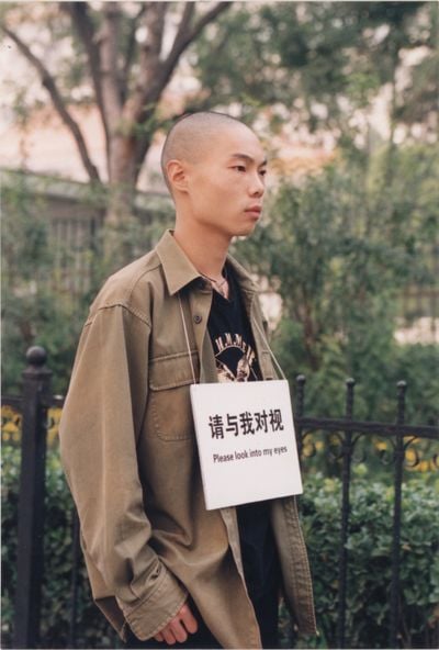 杨心广，《请与我对视》，2003。行为摄影，12.7×8.89cm。图片提供：艺术家。