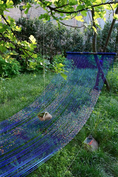 Sarah Sze, Landscape of Events Suspended Indefinitely (Hammock) (2015). Mixed media, including acrylic paint, string, cord, metal, stone, and archival photograph on Tyvek. 292.1 × 482.6 × 106.7 cm. Exhibition view: 56th Venice Biennale (9 May–22 November 2015). © Sarah Sze.
