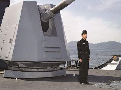 Heinkuhn Oh, A petty officer standing in front of 127mm naval artillery gun, October 2010 (2010). C Print. 151 x 191 cm.