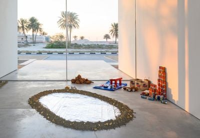 Léuli Eshrāghi, tagatanu'u (2017–ongoing). Performance with installation: sand, coconuts, coconut water, coconut milk, turmeric-infused water, charcoal, ochre, macadamia nuts, mylar emergency blankets, coconut scraping stool, metal bowls, books, digital images as slide presentation, cushions, rugs, plants. Dimensions variable. Exhibition view: Leaving the Echo Chamber, Sharjah Biennial 14 (7 March–10 June 2019). Commissioned by Sharjah Art Foundation.