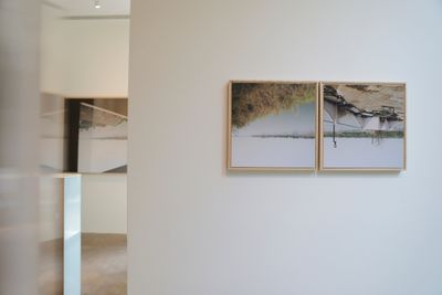 Upside down diptych print landscape and abandoned building side by side on gallery wall