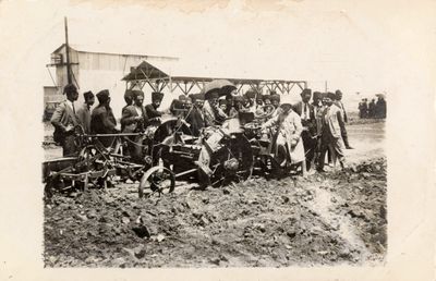 A group of men surround a tractor tilling soil at the Adana Agricultural Fair in 1924.