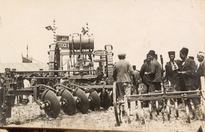 Machines and tractors are photographed alongside a group of men at the 1924 Adana Agricultural Fair.