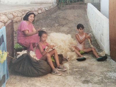 Artist Hana Miletić as a child is pictured with her sister and grandmother sorting through raw wool.