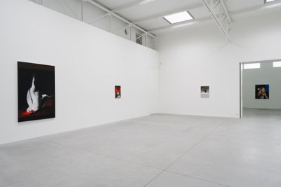 A white gallery space features a series of paintings by Mircea Suciu on the wall, the largest of which features a large white rooster hanging upside down against a black background.