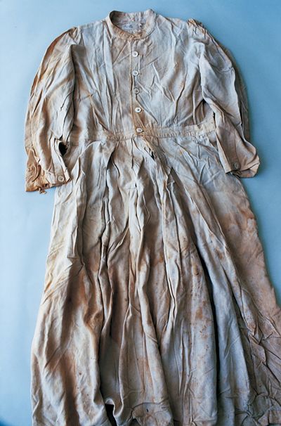 A brown tinted dress is photographed against a light blue background.
