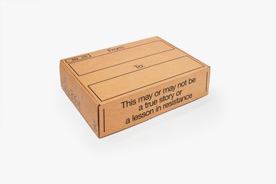 A cardboard box photographed against a white background reads 'This may or may not be a true story or a lesson in resistance'.