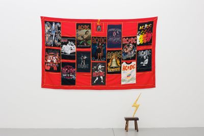 Nell, AC/DC Altar Cloth (from Chanting with Amps) (2012). Fabric and vintage T-shirts. 135.0 x 220.0 cm; Who Made Who/One on One (2004/13). Gold leaf, acrylic paint, varnishes, epoxy resin, wooden stool. 71.0 x 25.2 x 22.2 cm.