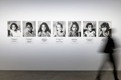 A series of seven black and white photographs of young children, forming an installation by Richard Bell in the gallery space