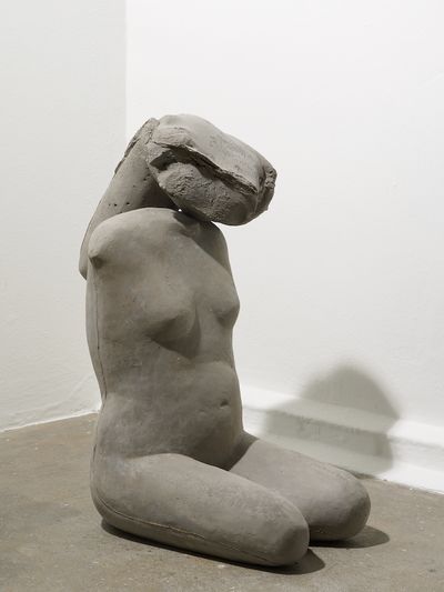 A female torso cast in concrete is photographed up close. It is one detail of an installation in the gallery space by Yu Ji.