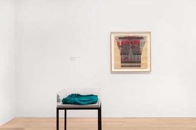 Left to right: Hand-knit wool sweater by the artist. Dimensions variable; Ellen Lesperance, Stop Men Energie Times Spectacular (2019). Gouache and graphite on tea-stained paper. 74.93 x 74.93 cm. Collection of Helen Kent-Nicoll and Edward J. Nicoll. Exhibition view: Amazonknights, Institute of Contemporary Art, Miami (30 November 2021–27 March 2022).