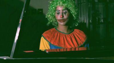 Farah Al Qasimi, Alone in a Crowd (King of Joy) (2020) (still). Improvised piano piece at a grand piano while wearing a Dragon Mart clown costume. 10 min. Edition of 3 + 1AP.