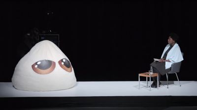 Dela Dabulamanzi and Stuffed Creature with Digitally Printed Eyes in the performance Stuffed Creatures also have a life, performed in 2018 at Haus Der Kulturen Der Welt, Berlin. Written and Directed by Hassan Khan.