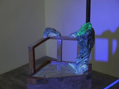 Jaffa Lam, Lost Limb Chair (2022) (detail). Recycled wood, recycled metal, concrete, abandoned chair, luminous paint on stone from Hong Kong quarantine camp, acrylic rods, and light bulb. 200 x 52 x 55 cm. Exhibition view: Chasing an Elusive Nature, Axel Vervoordt Gallery, Hong Kong (15 October 2022–7 January 2023).