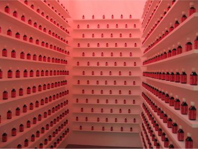 Shilpa Gupta, Blame (2002–2004). Interactive installation with Blame bottles, simulated blood, posters, stickers, video, interactive performance. 1 min 49 sec, loop. 300 x 130 x 340 cm.