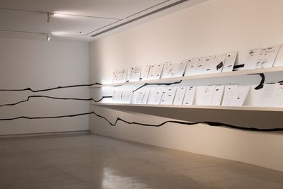 The Otolith Group, Who Does the Earth Think It Is? (2014). Installation with scanned letters, wooden shelves, and vinyl design. Exhibition view: Xenogenesis, Sharjah Art Foundation (13 November 2021–6 February 2022).