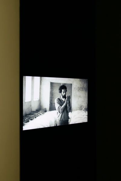 The Otolith Group, People to be Resembling (2012). 16:9 H.D. video with colour and sound, digital scans and archival photographs, seating, rug, flat screen. 21 min, 42 sec. Exhibition view: Xenogenesis, Sharjah Art Foundation (13 November 2021–6 February 2022).