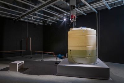 Pope.L, Choir (2019). Thousand-gallon plastic water-storage tank, water, drinking fountain, copper pipes, solenoid valves, pumps, MIDI controllers, electronic timer module, level-detection probe, flow meters, programmable logic controller, wood, scrim, vinyl letters, microphones, speakers, wires, and sound. Dimensions variable. Exhibition view: Whitney Museum of American Art, New York (10 October 2019–8 March 2020). © Pope.L.