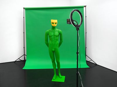 Puppies Puppies (Jade Guanaro Kuriki-Olivo), Mask (Grindr) • green • green screen backdrop • green screen mannequin• anon • anonymous figure • to be loved anonymously • behind closed doors • disappearance (2025). Exhibition view: Degenerate Art (Transsexual), Trautwein Herleth, Berlin (3 May–7 June 2025).