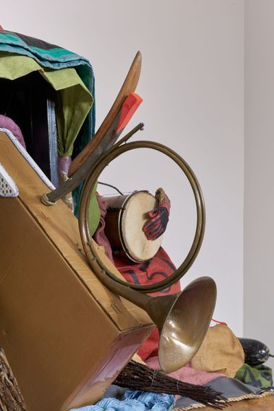 Daniel Lind-Ramos, El Viejo Griot (The Elder Storyteller) (2022–2023) (detail). Boat bow, burlap sacks, plastic lid, hat, wood, bugle, wood oars, cardboard, painted fibreglass, plastic and synthetic textiles, dried and lacquered coconuts, PVC bucket, tambourine, conga drum, gloves, wire, metal fasteners, mirror, sewing pins, marine rope, plastic wrapping material, and rope. 269.2 × 525.8 × 281.9 cm. Exhibition view: El Viejo Griot — Una historia de todos nosotros (The Elder Storyteller—A Story of All of Us), MoMA PS1, New York (20 April–4 September 2023).