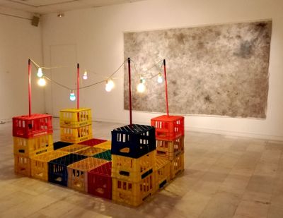 The Callas, Bellou (2004–2021). Plastic crates, wired bulbs, mops, and brooms. 210 x 160 x 125 cm; Tasting the floor, bands, real bands, people, real people, room expands and shrinks, cheap party lights, movement indicates rubbing, twist and turn, serpentine through sweaty bodies, purple booms, feedback crawls, disorientation of temporary feelings (2021). Charcoal, nail polish, lipstick, mascara, eyeliner, alcohol, ash, and body liquids. 210 x 330 cm. Exhibition view: Rembetiko curated by Christoforos Marinos, Athens Municipality Arts Center, Athens (10 February–3 April 2022).