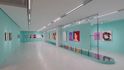 Colourful pop art portraits along light blue gallery walls.