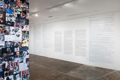 A series of pop cultural and historical images pertaining to racial politics are collaged on a wall. Part of it is visible to the left, and to the right a wall of text is visible.