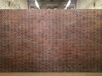A fake brick wall separates the gallery space of Rodeo in Athens.