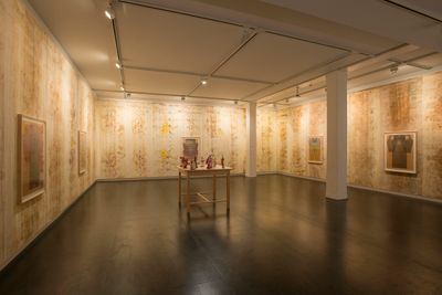 An installation by Ellen Lesperance features treated silk banners hang along the walls, which show light, earthy tones.