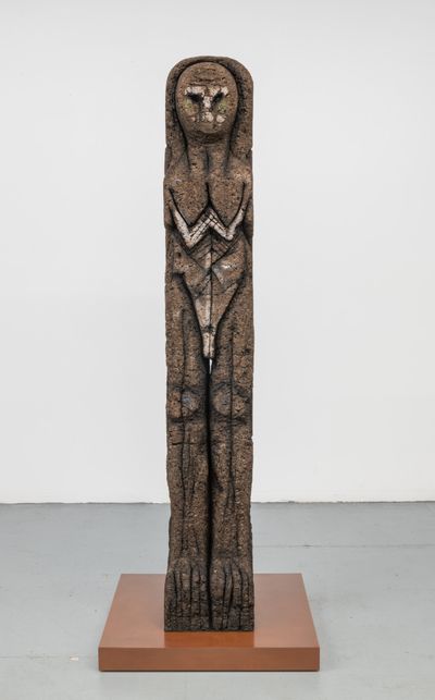 A totemic sculpture by Huma Bhabha in shades of brown that resembles a mix between a neolithic sculpture and an owl.
