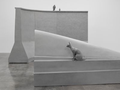 Artist Liu Wei's exhibition depicting 2 concrete-hued large-scale blocks with a cat sat on top and 2 birds perched on the higher block
