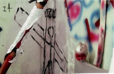 An early installation by Manuel Mathieu featuring graffiti on the wall and a dolls head
