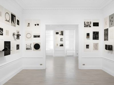 Black and white geometric imagery in varying sizes fill the walls of a white gallery space.