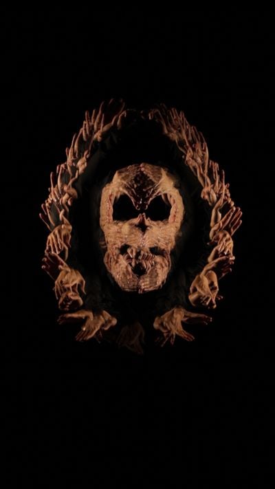 A video still features a series of hands that emerge from the darkness and overlap to create a skull formation.