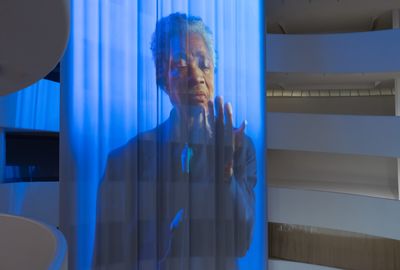 Inside the Guggenheim Museum hangs a long curtain projection of Wu Tsang's artwork portraying Glenn-Copeland singing while looking at his hands
