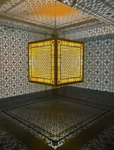Anila Quayyum Agha, Hidden Diamond – Saffron (2019). Laser-cut, lacquered steel. 122 x 122 x 122 cm.