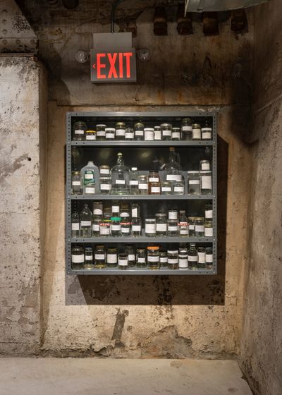 Marco Barrera, Drawing a line backwards (2022). Partial archive of New York City water: glass jars, steel Tri-Boro shelving unit, book. Exhibition view: In Practice: Literally means collapse, SculptureCenter, New York (12 May–1 August 2022).