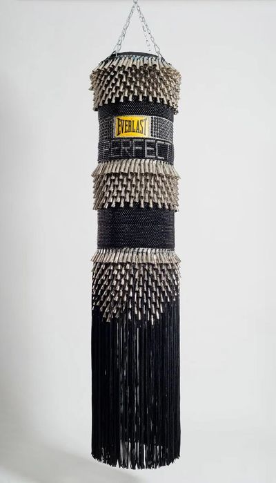 Jeffrey Gibson, I’m Not Perfect (2014). Found canvas punching bag, repurposed wool army blanket, glass beads, tin jingles, nylon fringe, artificial sinew, acrylic paint. 191.8 x 40.6 x 40.6 cm.