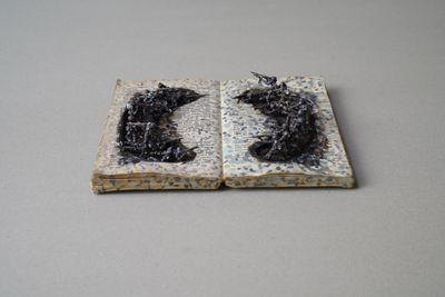 Kingsley Gunatillake, Protest XVII (2024). Used books and copper figures. 5 x 17.5 x 22.5 cm.