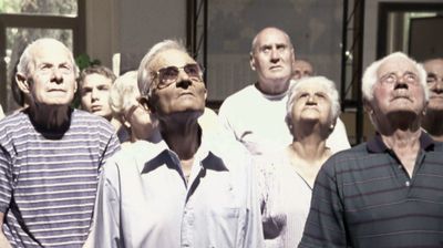 Film still showing a group of elderly men and women looking up to the sky.