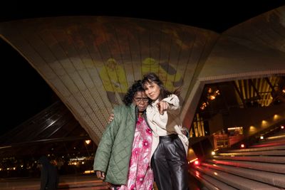 Artist Judith Inkamala (L) and the Art Gallery of New South Wales Curator of Aboriginal and Torres Strait Islander Art, Coby Edgar, with the artist's Ura kngarra mpintjama (A big fire is coming) (2020) projected on the sails of Sydney Opera House. Photo by Brook Mitchell/Getty Images for Art Gallery of NSW.