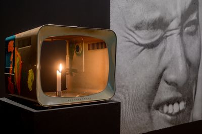 Nam June Paik, One Candle, also known as Candle TV (2004). Cathode ray tube television casing with additions in permanent oil marker, acrylic paint and live candle. Lent by the Estate of Nam June Paik. Installation view at the National Gallery Singapore.
