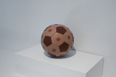 Nicola Costantino, Male Nipples Soccer Ball, Chocolate and Peach (2000). Installation view, 'BALLS' at OOF Gallery. Photo by Tom Carter.
