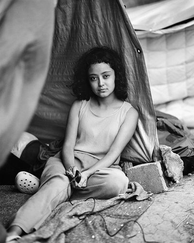 Adam Ferguson, Migrantes 02 (2021). Stephanie Solano, age 17, from Zacapa, Guatemala. She takes a portrait of herself at an informal migrant camp at a municipal park in Reynosa, Tamaulipas, Mexico on 3 May 2021. © Adam Ferguson.